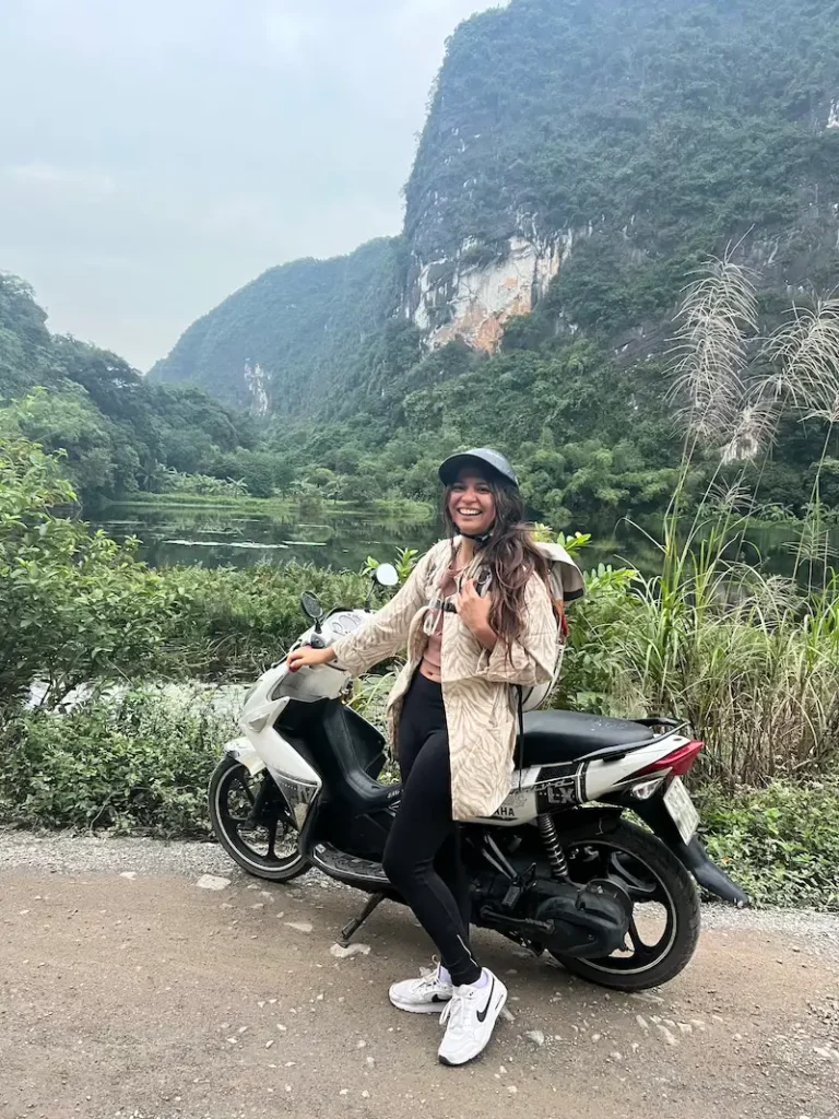 Danitza posando junto a una motocicleta en Trang An, Ninh Binh