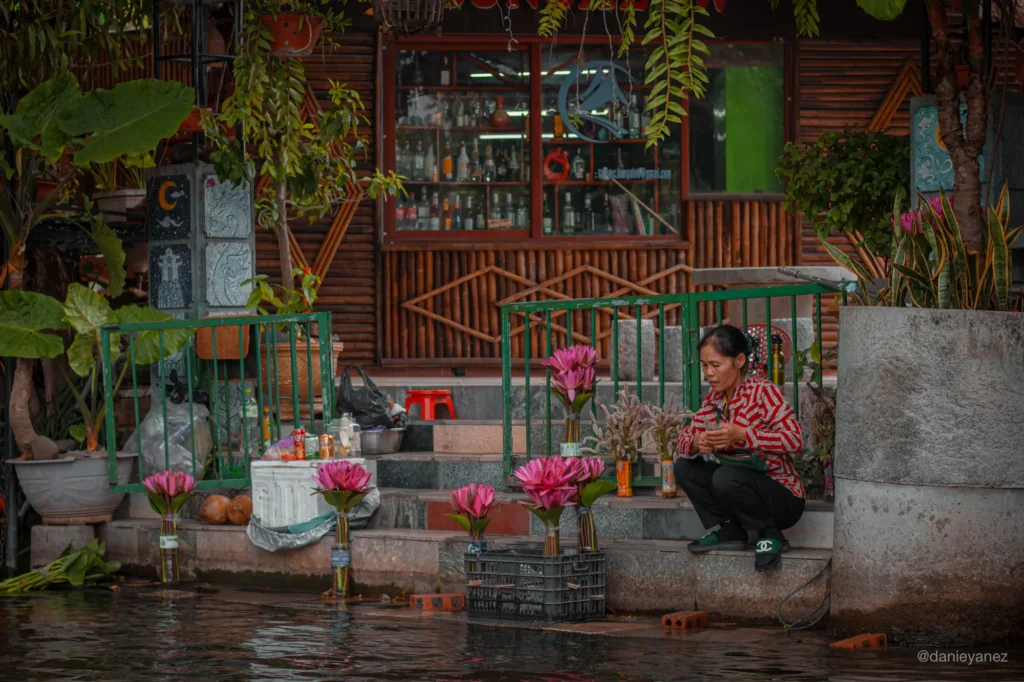 Mujer vietnamita vendiendo flores en el tour en barca de Tam Coc, Ninh Binh
