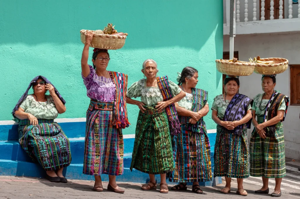 fotoperiodismo de viaje, seis mujeres con ropa tradicional guatemalteca esperando comenzar la procesión de frutas 